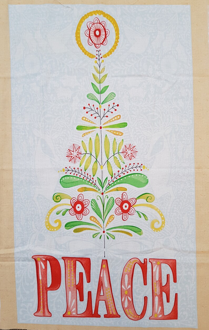 May include: A white fabric with a stylized floral design in shades of green, yellow, and red. The design resembles a Christmas tree with the word "PEACE" written in red letters with yellow and pink accents.