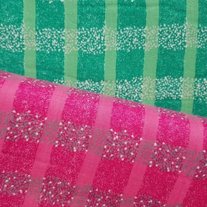 Peut inclure: Deux morceaux de tissu à motif à carreaux. Le tissu supérieur est vert avec des points blancs et le tissu inférieur est rose avec des points blancs.