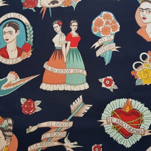 Op de afbeelding: Een donkerblauwe stof met een herhalend patroon van kleurrijke illustraties. De illustraties omvatten een hart met doornen, een vogel, een schaar, bloemen en een portret van Frida Kahlo. De tekst "Viva", "Frida", "Yo te esperare", "Ya no estoy sola", "El dolor", "El placer", "Y la muerte" en "Te amo mucho" is opgenomen in het patroon.