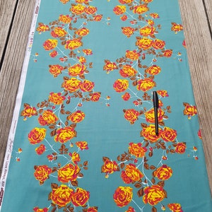 May include: Teal fabric with a repeating pattern of orange and yellow roses with brown stems and leaves. The fabric has the text "Love Always AM" printed on the side.