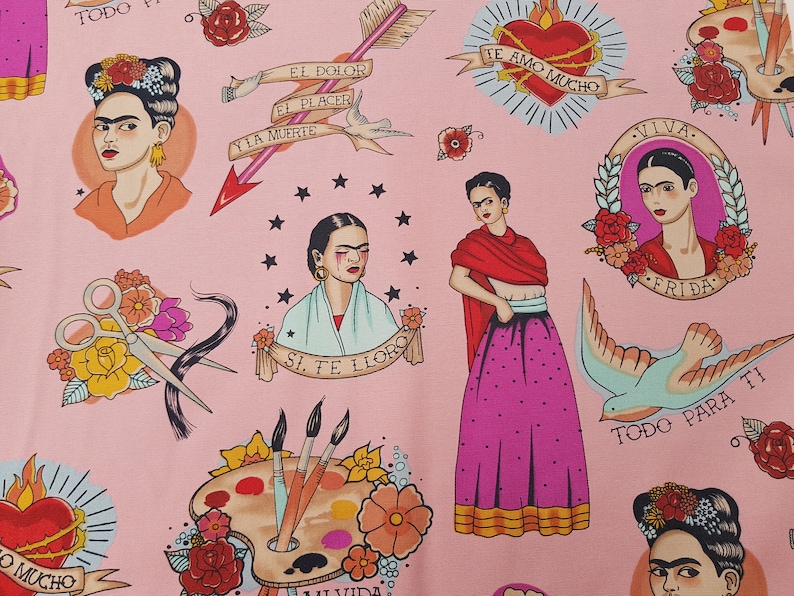 May include: Pink fabric featuring illustrations of Frida Kahlo, hearts, arrows, and text in Spanish. The design includes images of scissors, paint palettes, and doves, creating a vibrant and artistic pattern.