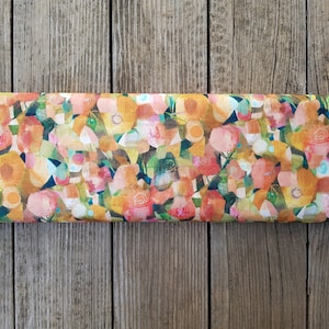 Puede incluir: Una tela con un patr&oacute;n floral en tonos naranja, amarillo, rosa y verde. Las flores son abstractas y parecen estar pintadas en estilo acuarela.