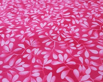 May include: Close-up of a vibrant pink fabric with a repeating pattern of white and light pink leaf-like shapes. The leaves are arranged in a dense, all-over design, creating a textured appearance. The fabric is likely cotton or a similar material.