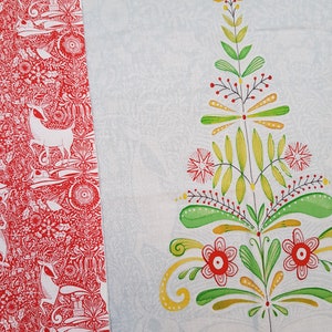 May include: Red and white fabric with a repeating pattern of stylized deer, birds, and floral designs. The fabric is next to a white fabric with a stylized green and yellow tree with red flowers and the word "PEACE" in red.