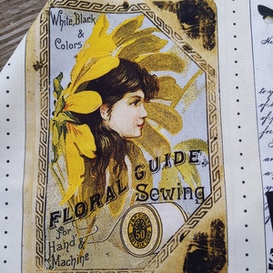 Op de afbeelding: Een stoffen paneel met een vintage bloemen naaigids ontwerp. Het ontwerp bevat een portret van een vrouw met gele bloemen, de tekst "White, Black & Colors" en "FLORAL GUIDE Sewing for Hand & Machine".