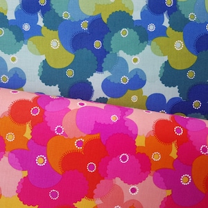 May include: Two fabric swatches with a floral pattern. The top swatch is light blue with blue, green, and white flowers. The bottom swatch is pink with pink, orange, and white flowers.