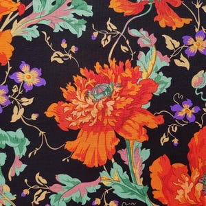 May include: A black fabric with a floral pattern featuring large orange and red poppies with green leaves and small purple flowers.