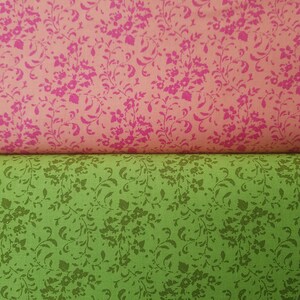 May include: Two pieces of fabric with a floral pattern. The top piece is pink with a dark pink floral pattern. The bottom piece is green with a dark green floral pattern.