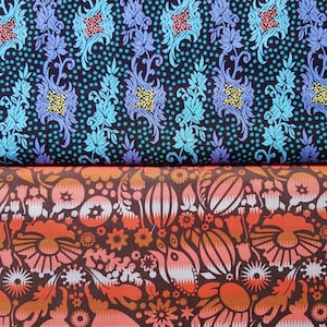 May include: Two fabric swatches with floral patterns. The top swatch has a dark blue background with a light blue and teal floral pattern. The bottom swatch has a dark brown background with a pink, orange, and white floral pattern.