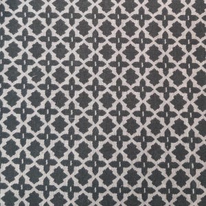 Puede incluir: Una tela negra y blanca con un patrón geométrico repetitivo. El patrón está formado por pequeñas figuras con forma de diamante.