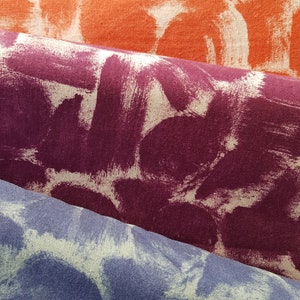 May include: Three fabric swatches with a white paint splatter design. The top swatch is orange, the middle swatch is purple, and the bottom swatch is blue.