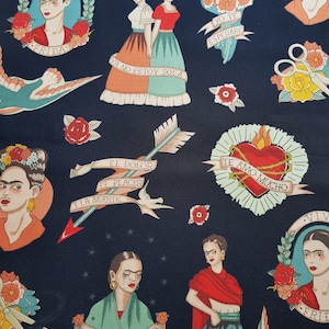 Op de afbeelding: Een donkerblauwe stof met een herhalend patroon van Frida Kahlo ge&iuml;nspireerde illustraties. De illustraties omvatten portretten van Frida Kahlo, bloemen, harten, vogels en tekst in het Spaans. De tekst omvat "Viva", "Frida", "Ya no estoy sola", "Yo te esperare", "El dolor", "El placer", "Y la muerte", "Te amo mucho" en "Si te lloro".