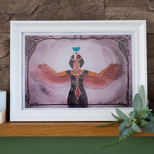 Peut inclure: Une peinture à l'aquarelle encadrée d'une déesse ailée avec une couronne et les bras tendus. L'arrière-plan est d'un violet doux avec une bordure décorative.