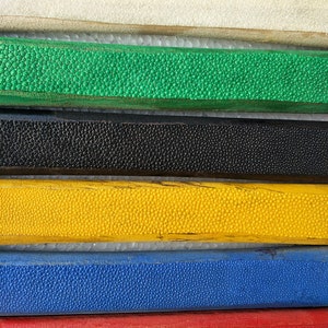 May include: Five wooden sticks with different colored finishes. The sticks are arranged vertically with the white stick at the top and the red stick at the bottom. The sticks have a textured surface.