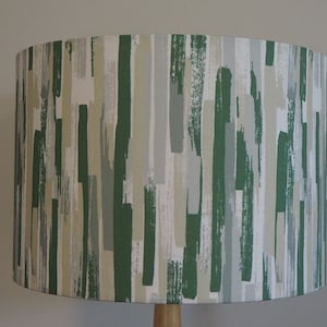 May include: A lampshade with an abstract brushstroke pattern in shades of green, beige and grey.