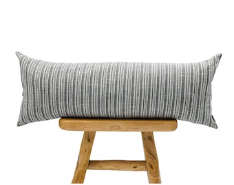 May include: A long rectangular lumbar pillow featuring a dark gray and white vertical pinstripe pattern. The fabric has a visible woven texture with alternating thin white lines against a charcoal gray background, creating a classic striped design.