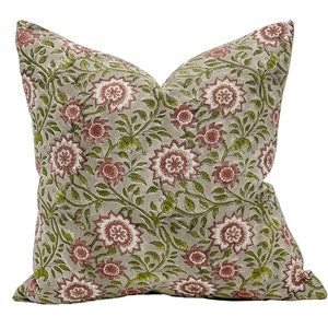 May include: A grey and white cushion with a floral pattern in shades of pink and green. The cushion is made of a soft, linen-like fabric.