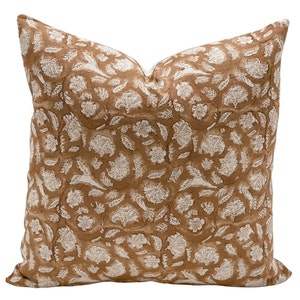 May include: A brown and white patterned throw pillow with a floral design.