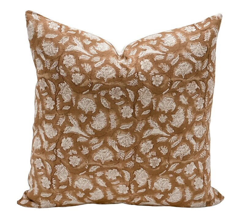 May include: A brown and white patterned throw pillow with a floral design.