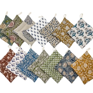 May include: Set of 15 colorful fabric pot holders with floral patterns. The pot holders are made of cotton and have a loop for hanging.