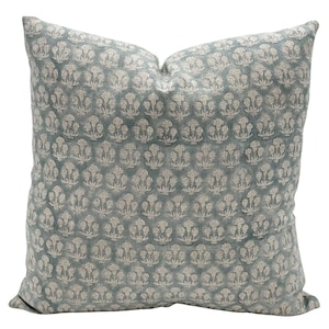 May include: A blue throw pillow with a white floral pattern. The pillow is made of a soft, textured fabric.
