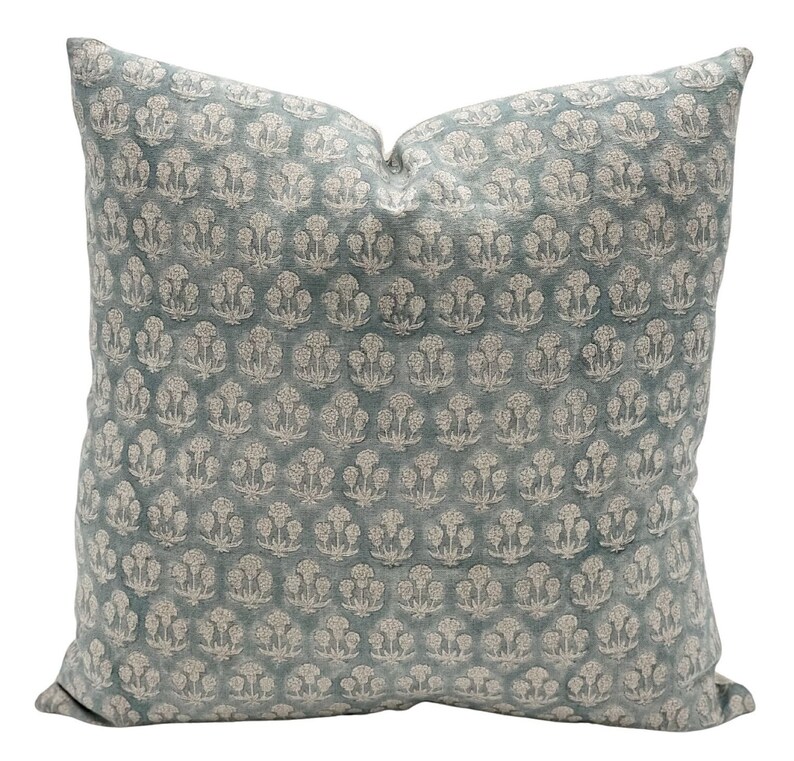 May include: A blue throw pillow with a white floral pattern. The pillow is made of a soft, textured fabric.