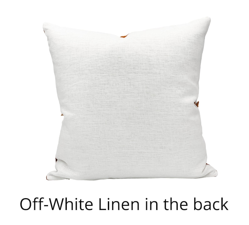 Puede incluir: Almohada de lino de color blanco roto con una textura sutil. La parte posterior de la almohada es visible, mostrando la tela de lino.