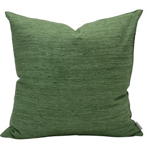 Puede incluir: Una almohada cuadrada verde con tejido texturizado.