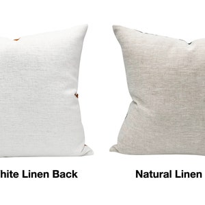 Pode incluir: Duas almofadas quadradas de linho. Uma &eacute; branco sujo, a outra &eacute; linho natural. Ambas t&ecirc;m uma apar&ecirc;ncia texturizada e detalhes marrons. O texto na imagem diz "Off White Linen Back" e "Natural Linen Back".