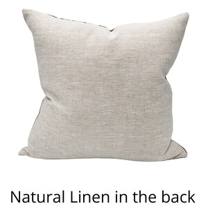 May include: A natural linen pillow with a black trim. The back of the pillow is made of natural linen.