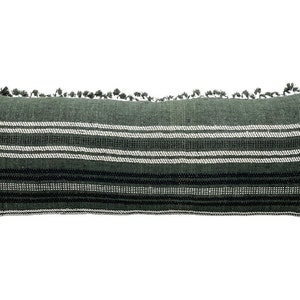 Pode incluir: Uma almofada decorativa longa e retangular em tons de verde, branco e preto. A almofada apresenta listras horizontais e &eacute; adornada com pequenas borlas ao longo da borda superior. A almofada &eacute; projetada para decora&ccedil;&atilde;o de casa.