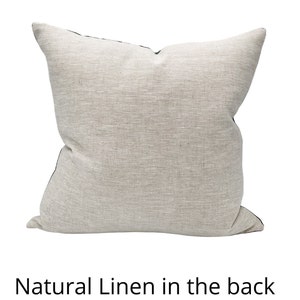 Puede incluir: Una almohada cuadrada con un frente de lino natural y una parte posterior de color verde oscuro. La almohada est&aacute; hecha de una tela suave y texturizada.