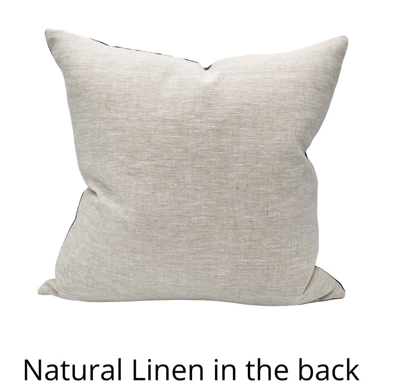 Puede incluir: Una almohada cuadrada con un frente de lino natural y una parte posterior de color verde oscuro. La almohada est&aacute; hecha de una tela suave y texturizada.