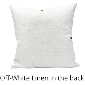May include: Off-white linen pillow with a textured surface. The pillow has a square shape and features brown accents on the corners. The text "Off-White Linen in the back" is at the bottom of the image.