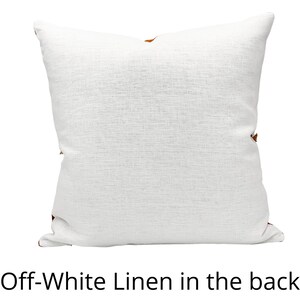 May include: Off-white linen pillow with a brown accent. The pillow is shown from the back.