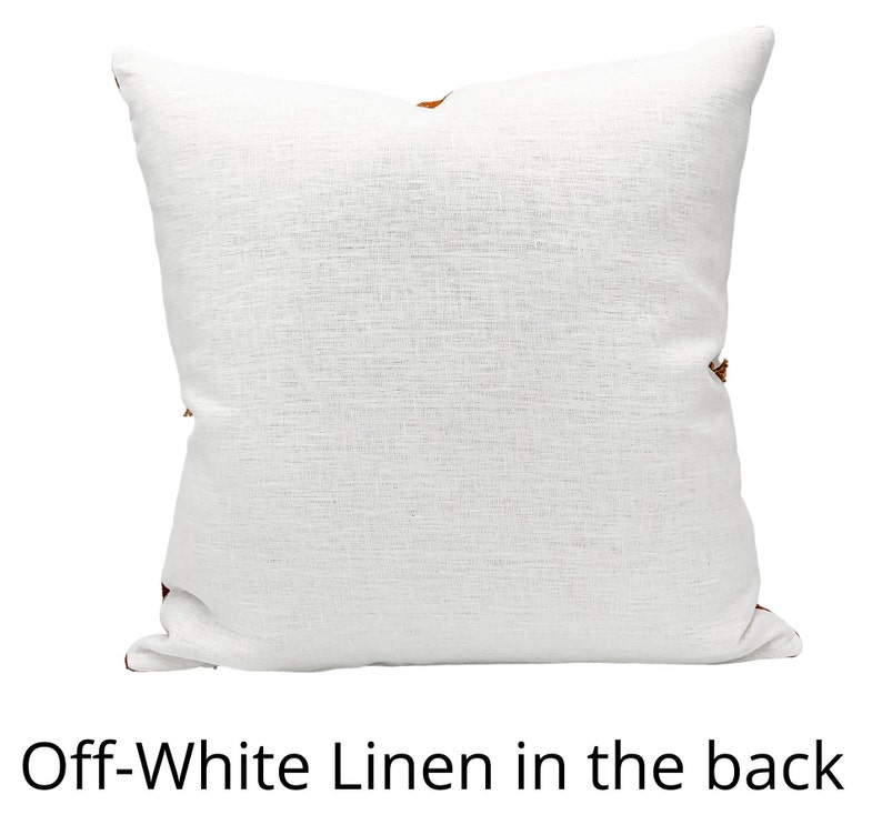 Pu&ograve; includere: Cuscino quadrato in lino bianco sporco con superficie strutturata. Il cuscino ha un accento marrone sugli angoli. Il testo "Off-White Linen in the back" &egrave; in basso nell'immagine.