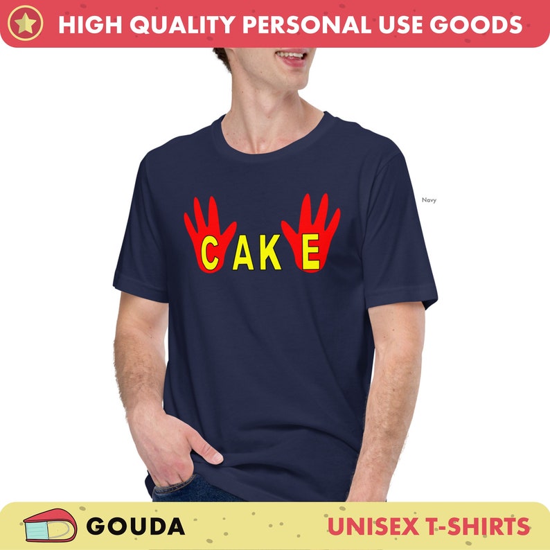 May include: A navy blue unisex t-shirt featuring the word "CAKE" in yellow, flanked by red handprints. The short-sleeved shirt is suitable for everyday wear. The text "HIGH QUALITY PERSONAL USE GOODS" is at the top.