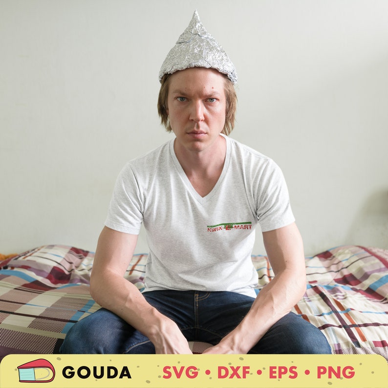 May include: A person wearing a silver foil hat sits on a bed with a plaid bedspread. The person is wearing a white t-shirt with the text "Kwik-Mart" printed on the front.