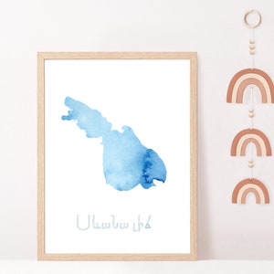 May include: A framed watercolor print of a blue island with the text "Ullastret" in white below the island.