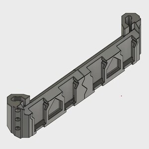 May include: A gray, geometric 3D-printed object with a rectangular shape and various cut-out sections. The design features angular lines and a symmetrical structure, with cylindrical elements at each end. The object appears to be a component or part.