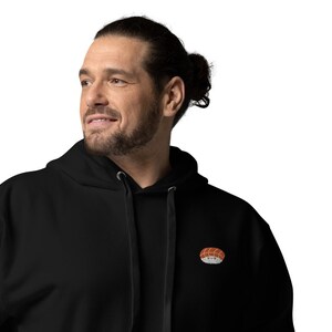 May include: A black hooded sweatshirt with a small embroidered sushi design on the left chest.