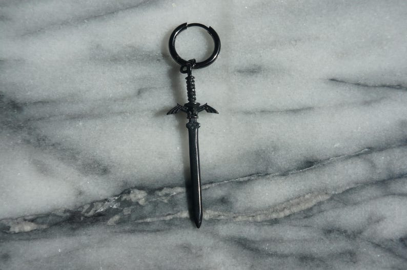 May include: Black sword-shaped earring with a hoop design. The sword has a winged design at the top and a pointed tip.