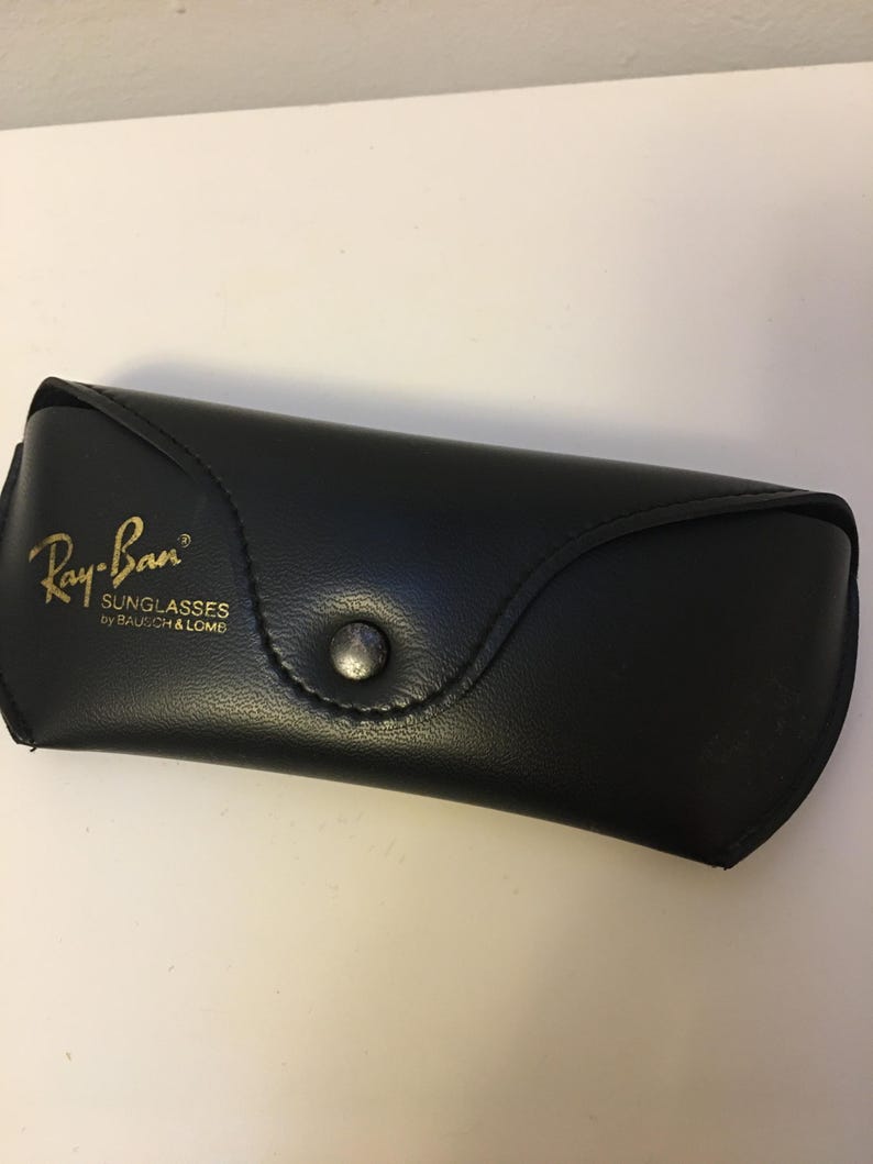 May include: A white ceramic mug with a black handle and the text "But First, Coffee" in a bold, black font. The mug is sitting on a wooden surface. The mug is approximately 4 inches tall.