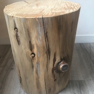 Könnte beinhalten: Ein Hocker aus Naturholz mit rustikalem Finish. Der Hocker besteht aus einem einzigen Stück Holz und hat eine natürliche Rindenkante. Der Hocker ist etwa 46 cm hoch und 30 cm im Durchmesser.