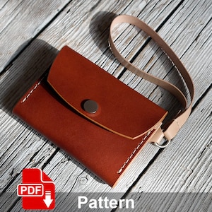 Puede incluir: Una cartera de cuero marrón con cierre de solapa y botón a presión. La cartera tiene una pequeña correa. La cartera está sobre una superficie de madera.  PDF Pattern