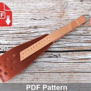 May include: A brown leather camera strap with a tan leather accent and a metal loop. The strap has a perforated design and the text "PDF Pattern" is printed below the strap.