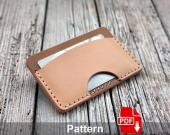 May include: A tan leather card holder with a stitched edge. The card holder has a slot for a card and a flap that folds over the top.