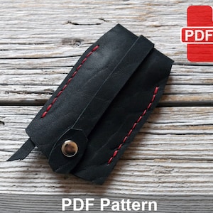 May include: Black leather key holder with red stitching and a metal snap closure. PDF Pattern.