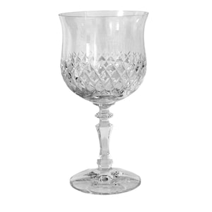 May include: A clear crystal wine glass with a diamond-cut pattern on the bowl. The glass has a long stem and a round base. The bowl is tulip-shaped, and the glass is designed for serving wine.