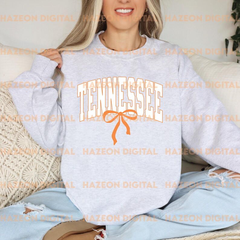 May include: A grey sweatshirt with the word "Tennessee" in white letters with an orange bow underneath.